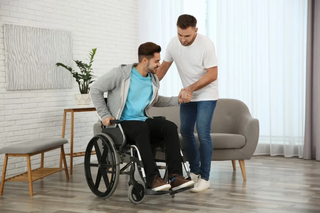 Support worker helping man in wheelchair at home